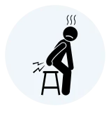 Simple medical icon showing a person experiencing severe pain while sitting, representing piles, anal fissure, or rectal discomfort.